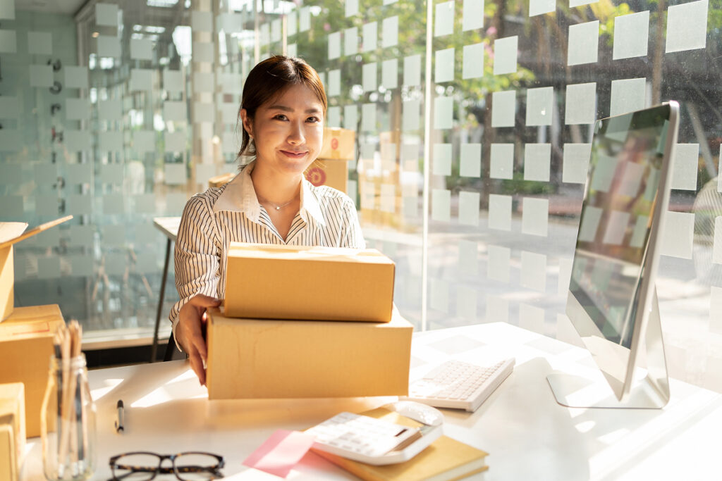 Businesswoman at desk with shipping boxes