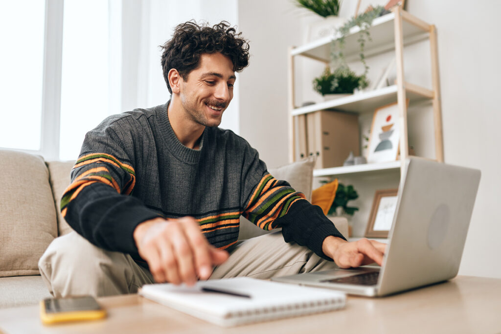 Man sitting in living room on laptop smiling